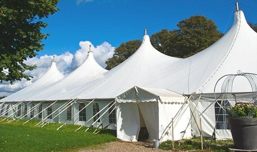 tall green portable restrooms assembled at a music festival, contributing to an organized and sanitary environment for guests in Phillipsburg